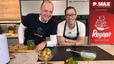 Chefkoch Peter Lehner und Ronnie Weger stehen lächelnd in einer modernen Küche hinter einer Arbeitsplatte mit einem frisch zubereiteten Basilikum-Cocktail und einem Garnelensalat. Die Speisen und Getränke sind in eiskalten Gläsern angerichtet, die mithilfe des links im Bild sichtbaren „freecer“-Geräts gekühlt wurden.