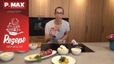 Koch Peter Lehner steht in einer modernen Küche und präsentiert die Zutaten für das Rezept. Vor ihm auf der Arbeitsplatte stehen das fertig angerichtete Gericht aus gebratenem Karfiol mit Hummus sowie Schüsseln mit Karfiolröschen und einem aufgeschnittenen Granatapfel.