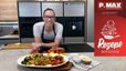 Koch Peter Lehner präsentiert lächelnd eine Platte mit den drei vegetarischen Ofengemüse-Gerichten: Brokkoli mit Mandeln, Karotten mit Sesam und Kohlsprossen mit Erdnüssen. Er steht in einer modernen Küche vor hochwertigen Einbaugeräten, wobei die verschiedenen Zutaten dekorativ auf der Arbeitsplatte angerichtet sind.