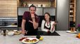 Tanja Pfaffeneder und Philipp von „Philipp bewegt“ präsentieren in einer modernen Küche das Trend-Rezept Cloud Bread. Im Vordergrund ist ein Teller mit dem fertig belegten, proteinreichen Brot mit Avocado und Tomaten zu sehen, während die beiden Gastgeber mit frischen Zutaten posieren.