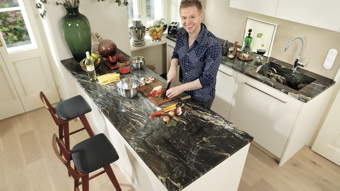 Koch beim Kochen in Wohnküche.